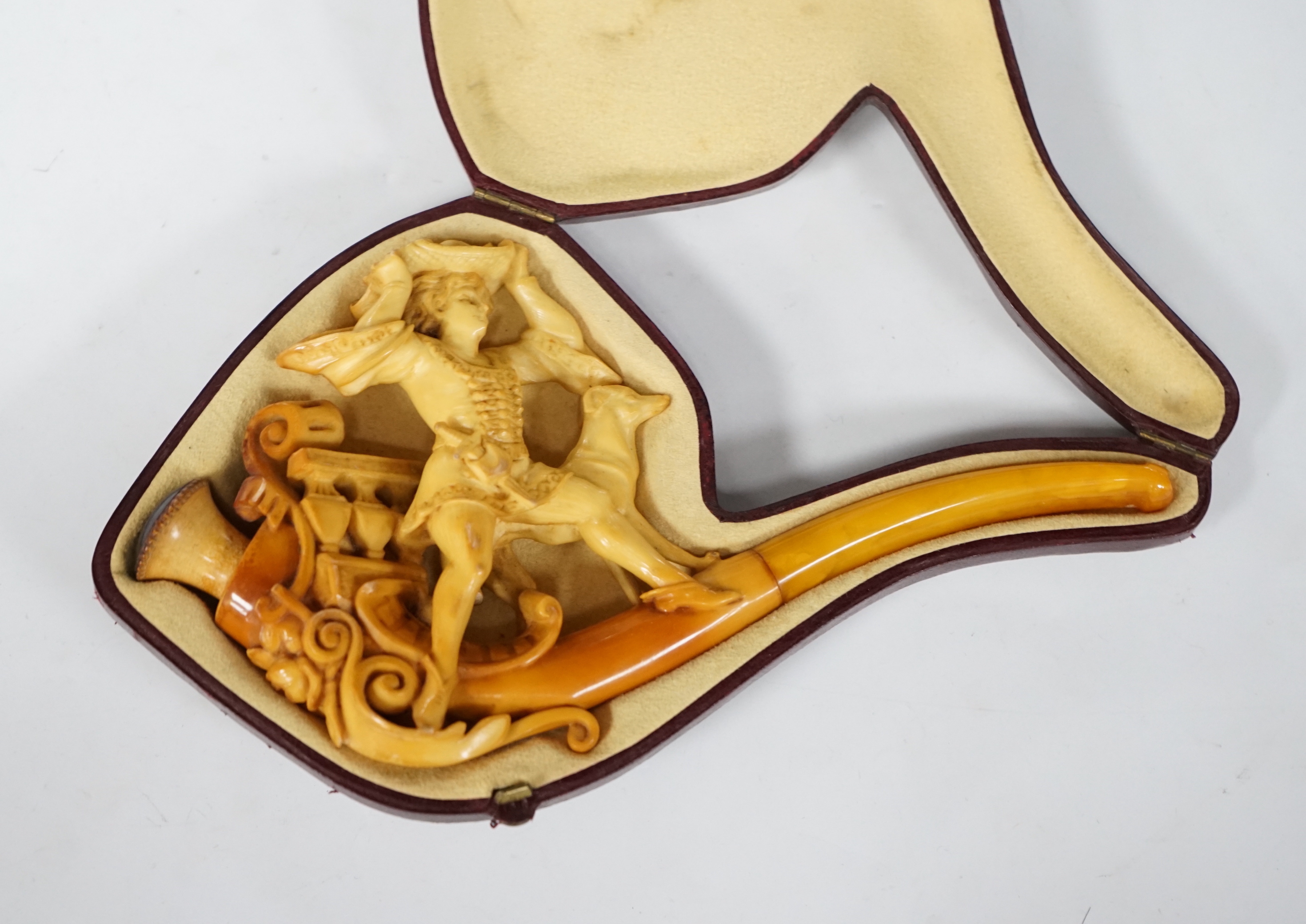 A cased Meerschaum pipe, the bowl in the form of a 17th century huntsman with his dog, 19cm long